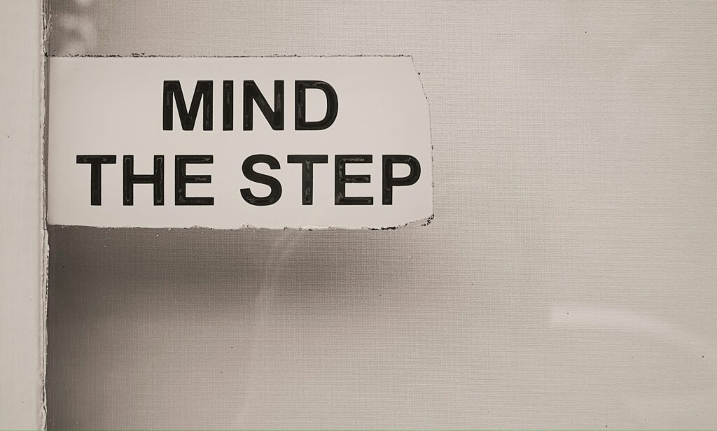 MIND THE STEPの表示、お金のブロック解消の段階的プロセスを象徴