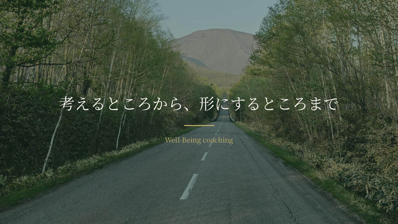 木立の間をまっすぐ伸びる道の先に立つ山。「考えるところから、形にするところまで」の文字