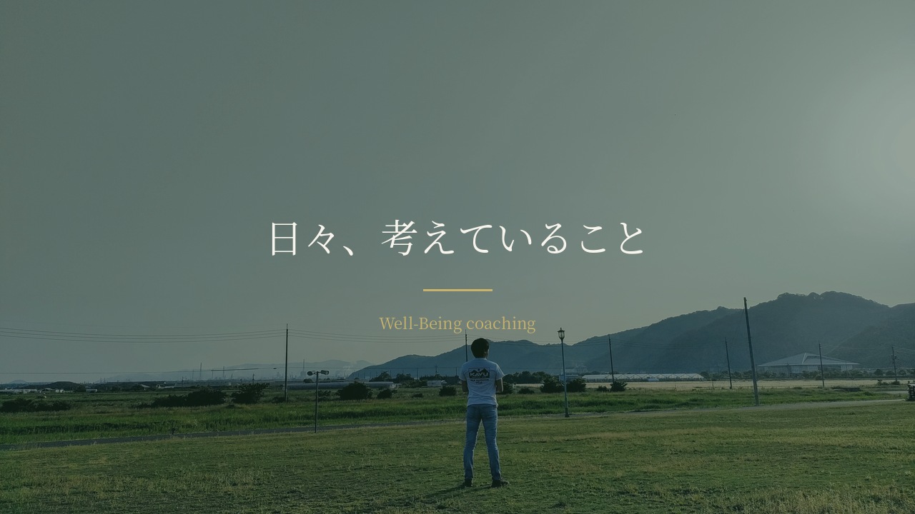 広い草地に一人で立ち、遠くの山を見ている後ろ姿。「日々、考えていること」の文字
